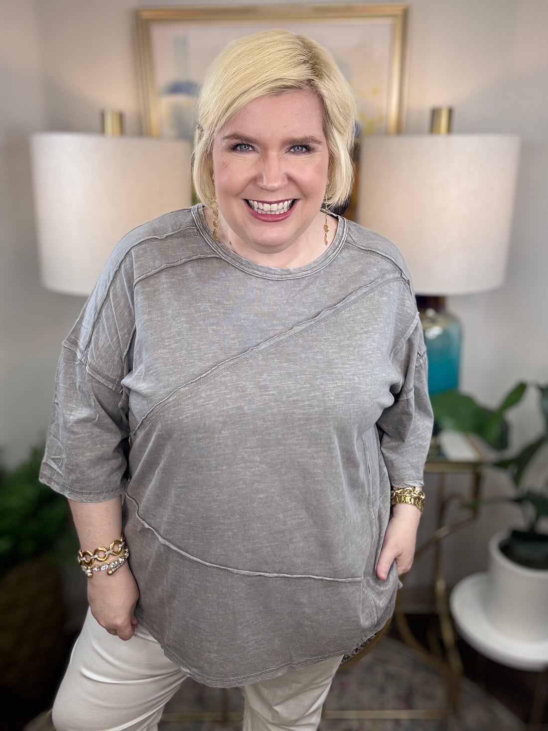 Woman wearing a gray t-shirt blouse. 