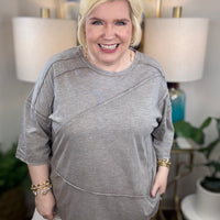 Woman wearing a gray t-shirt blouse. 