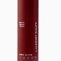 Maroon bottle of laundry sauce with white text on a white background