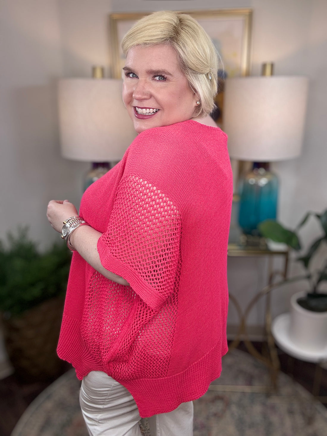 Woman wearing a pink short-sleeved tunic sweater.