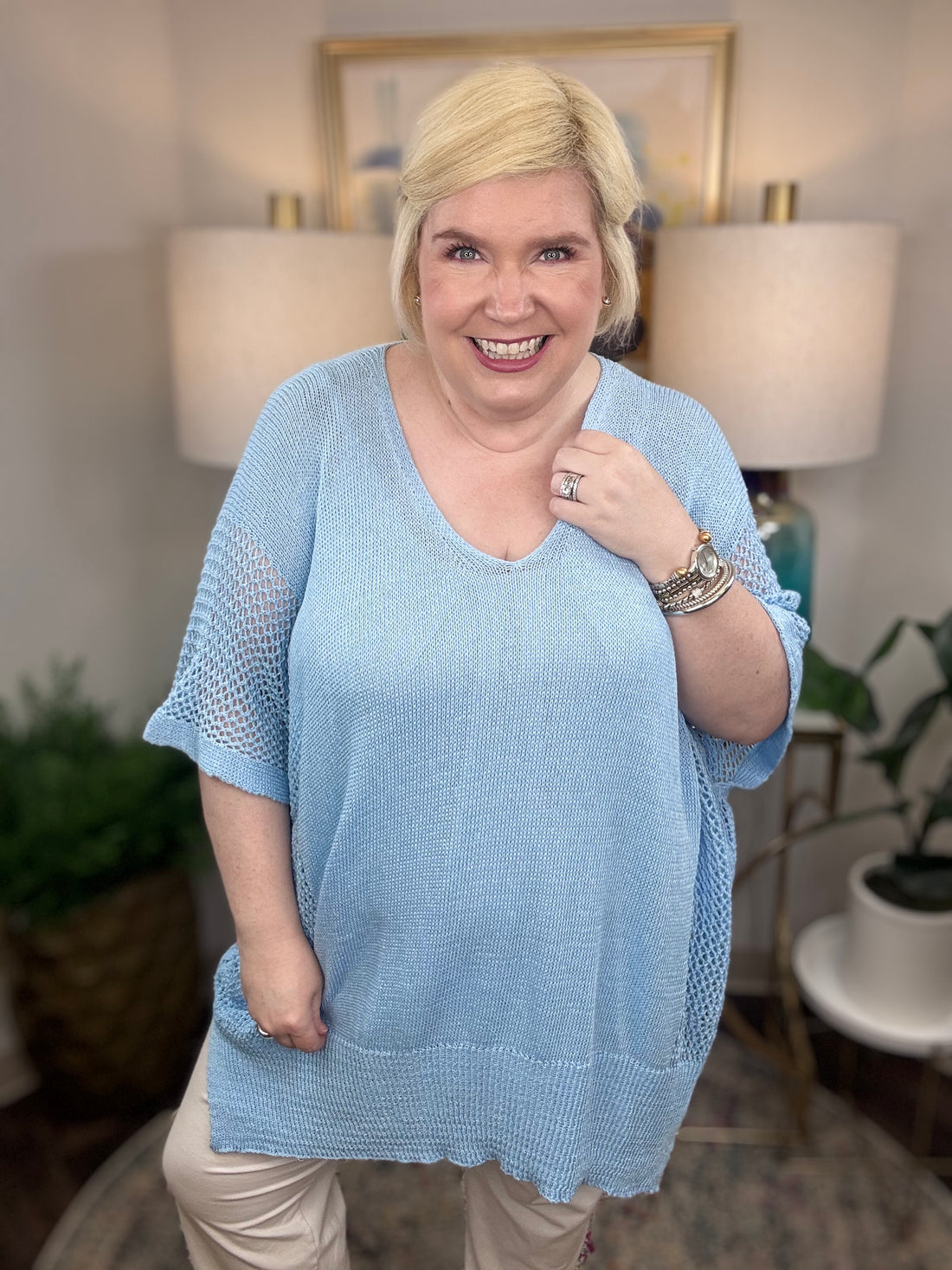 Woman wearing a light blue short-sleeved tunic sweater.