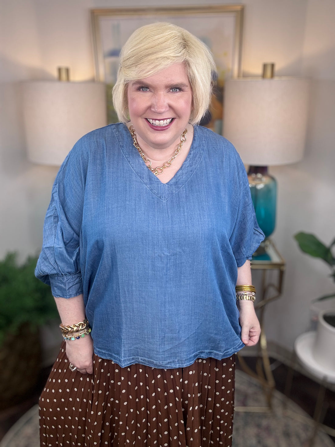 Woman wearing a denim v-neck dolman sleeve blouse