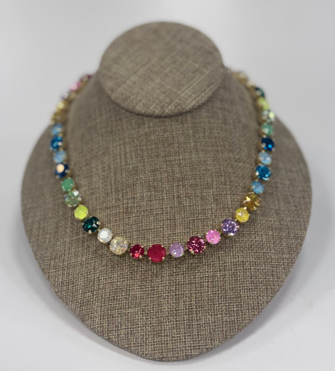 Multicolored beaded necklace on a brown jewelry display