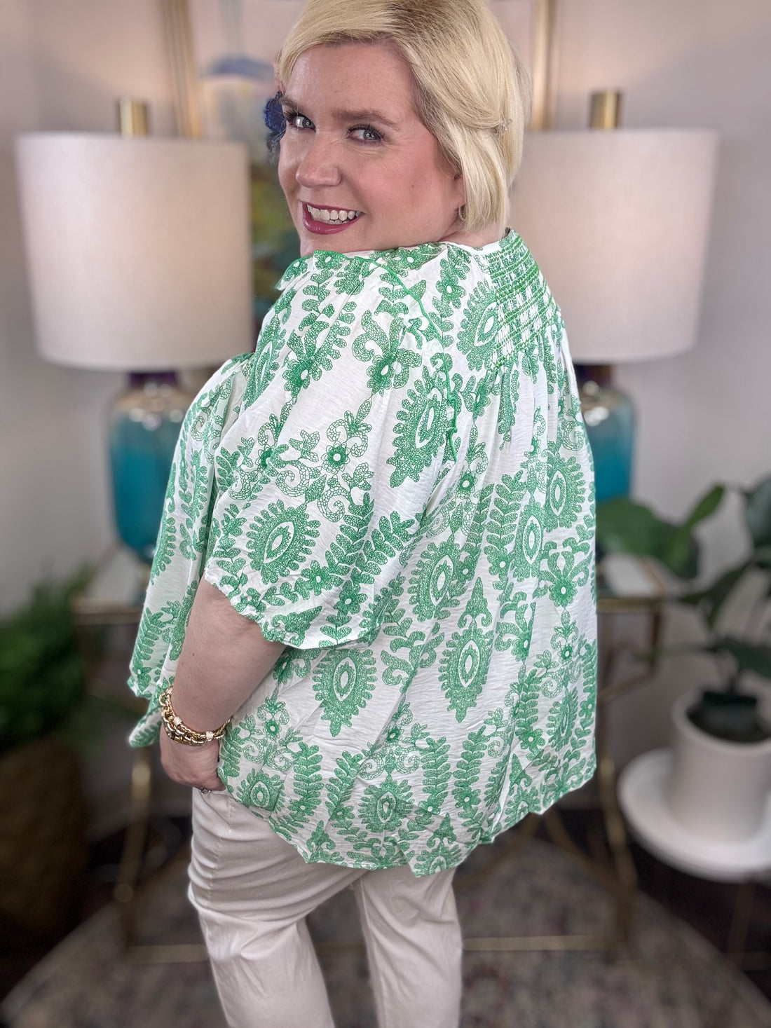 Woman wearing a green and white blouse. 