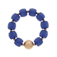 Blue beaded bracelet with a gold accent on a white background