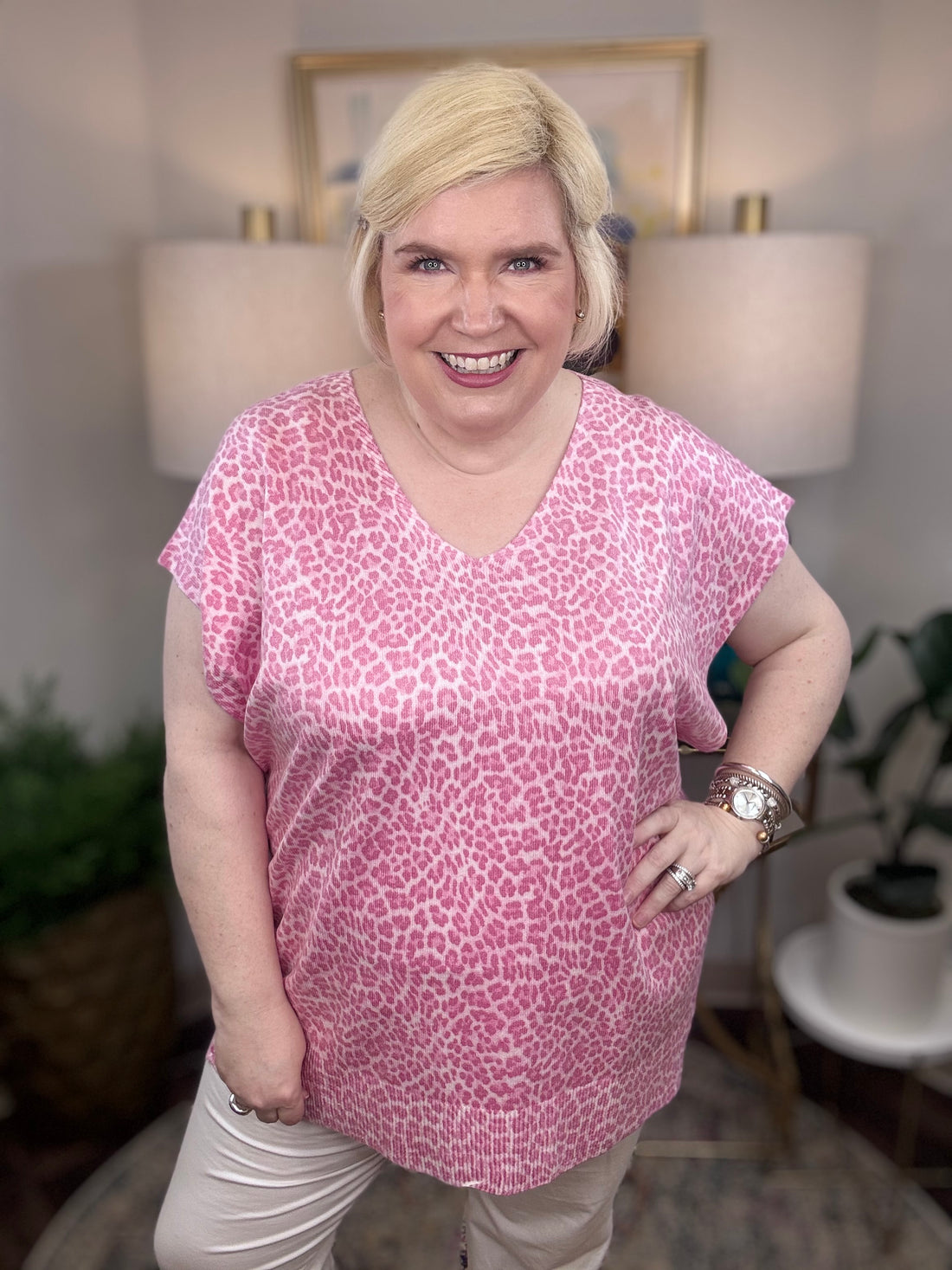 Woman wearing a pink leopard patterned blouse.