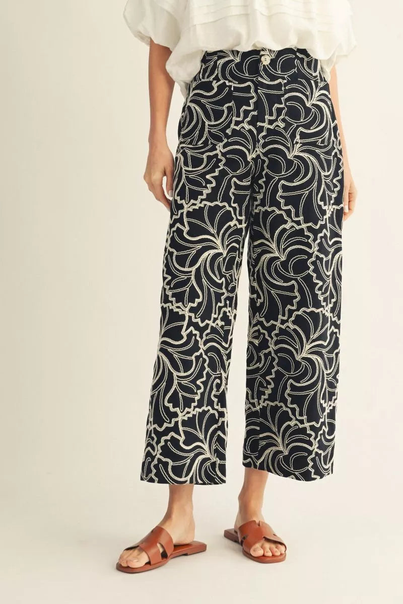 Person wearing black and white patterned pants on a light background