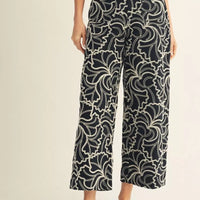 Person wearing black and white patterned pants on a light background