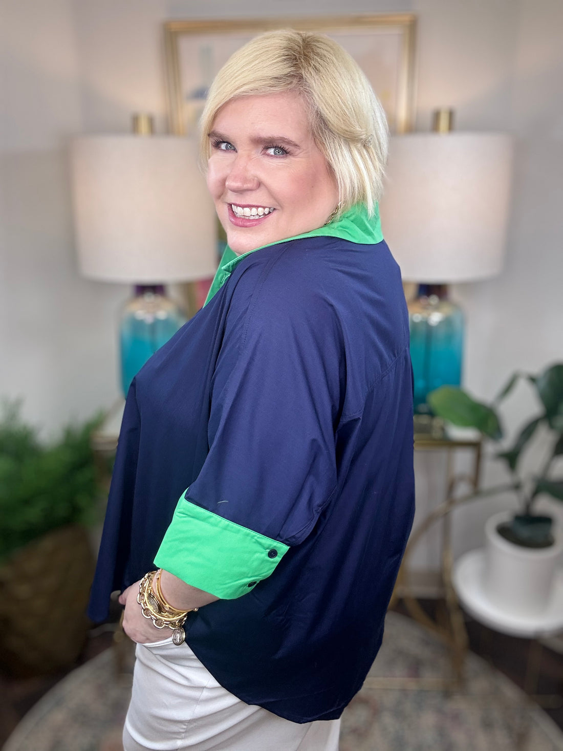 Woman wearing a navy shirt with green color-block accents.