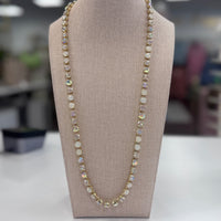 Opal-style white and clear stoned necklace on a mannequin bust with a blurred indoor background