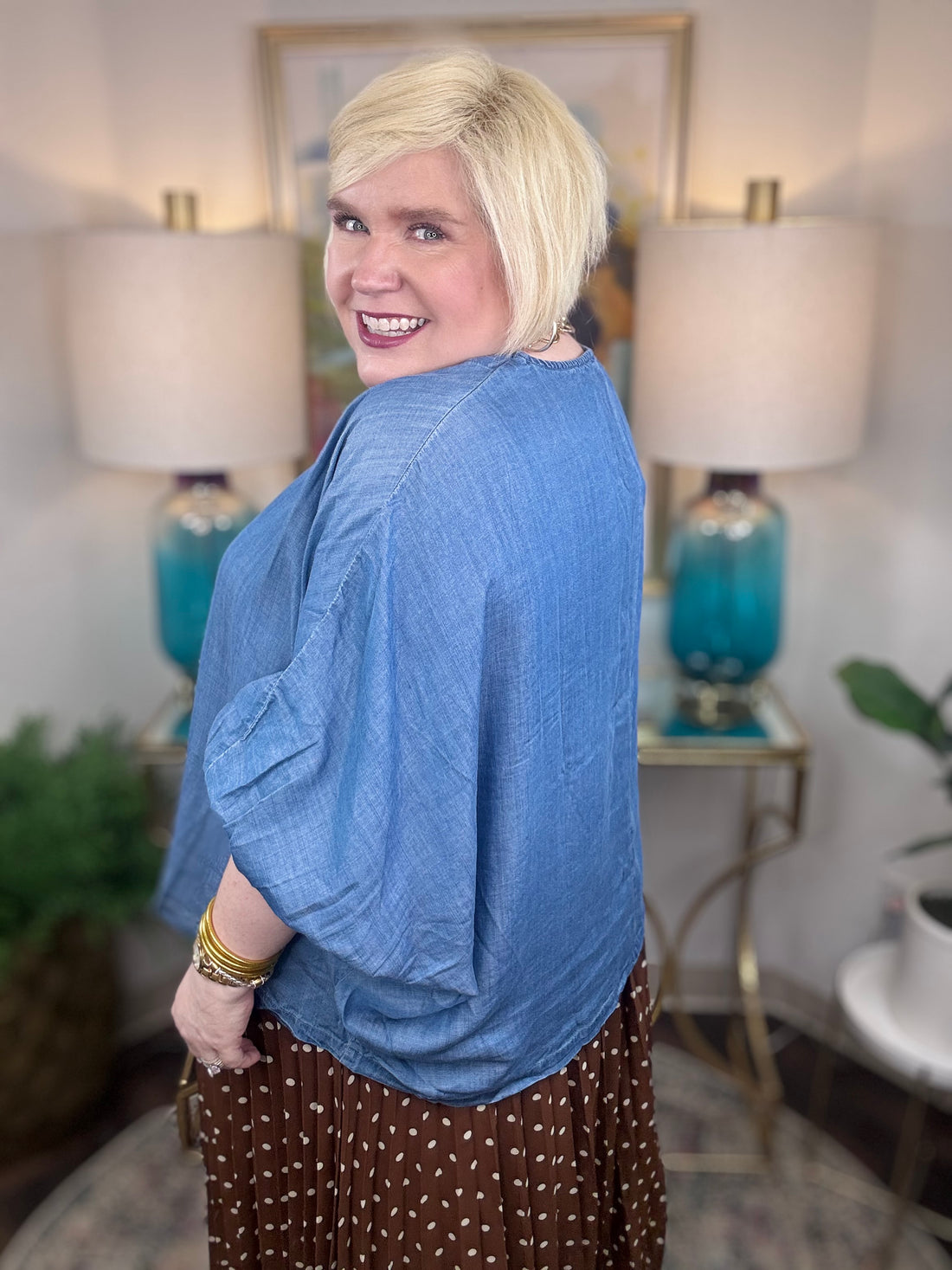 Woman wearing a denim v-neck dolman sleeve blouse