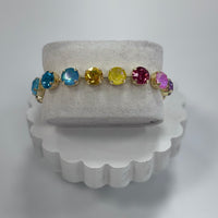 Jewelry display with a bracelet featuring multicolored gemstones on a white stand.