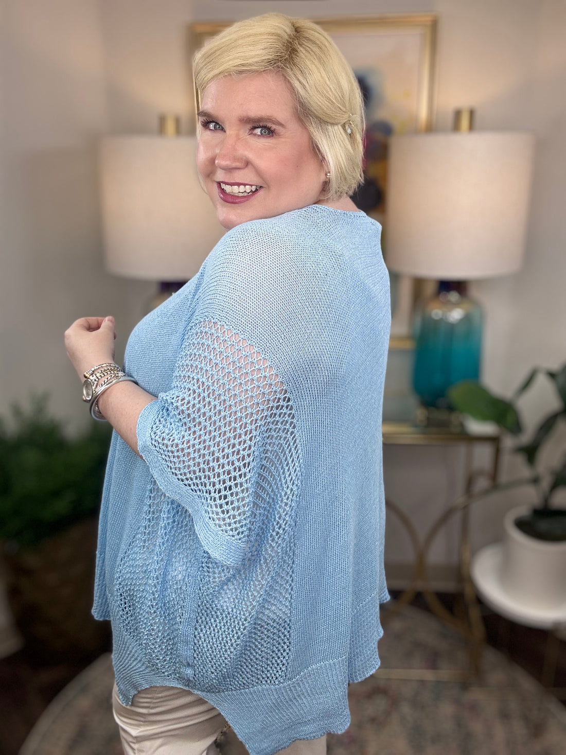 Woman wearing a light blue short-sleeved tunic sweater.