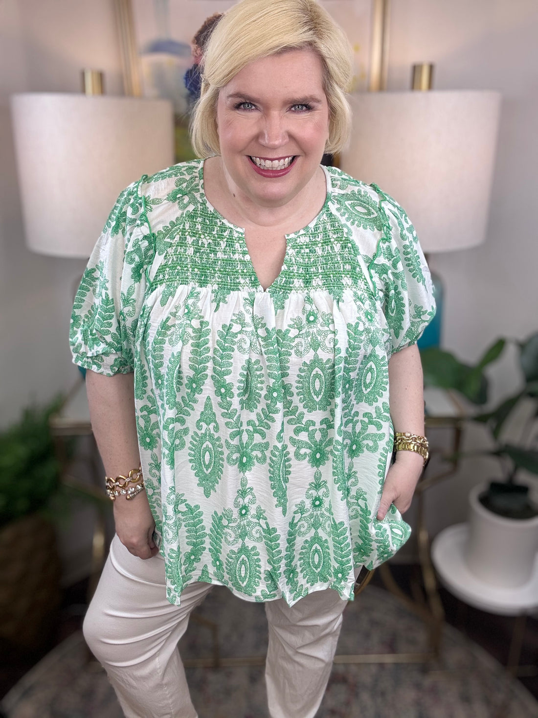 Woman wearing a green and white blouse. 