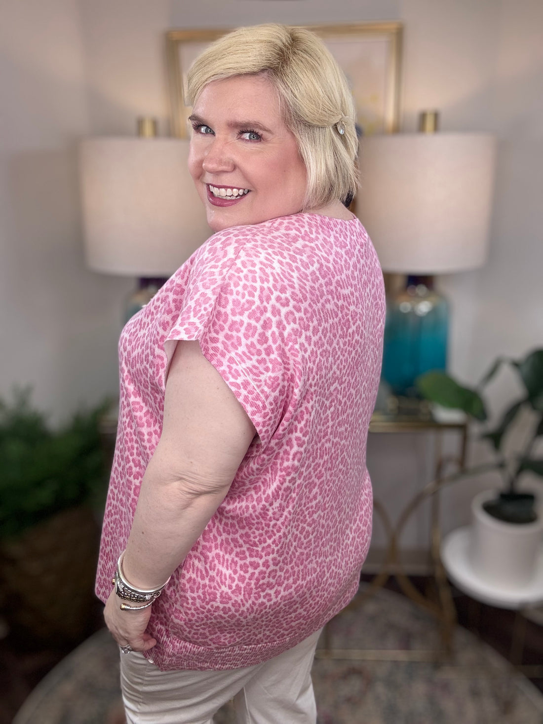Woman wearing a pink leopard patterned blouse.