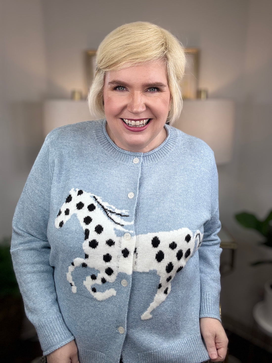 Light blue cardigan with white horse and black spots