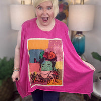 woman wearing a sleeveless bright pink top with a large colorful Frida Kahlo graphic print on the front