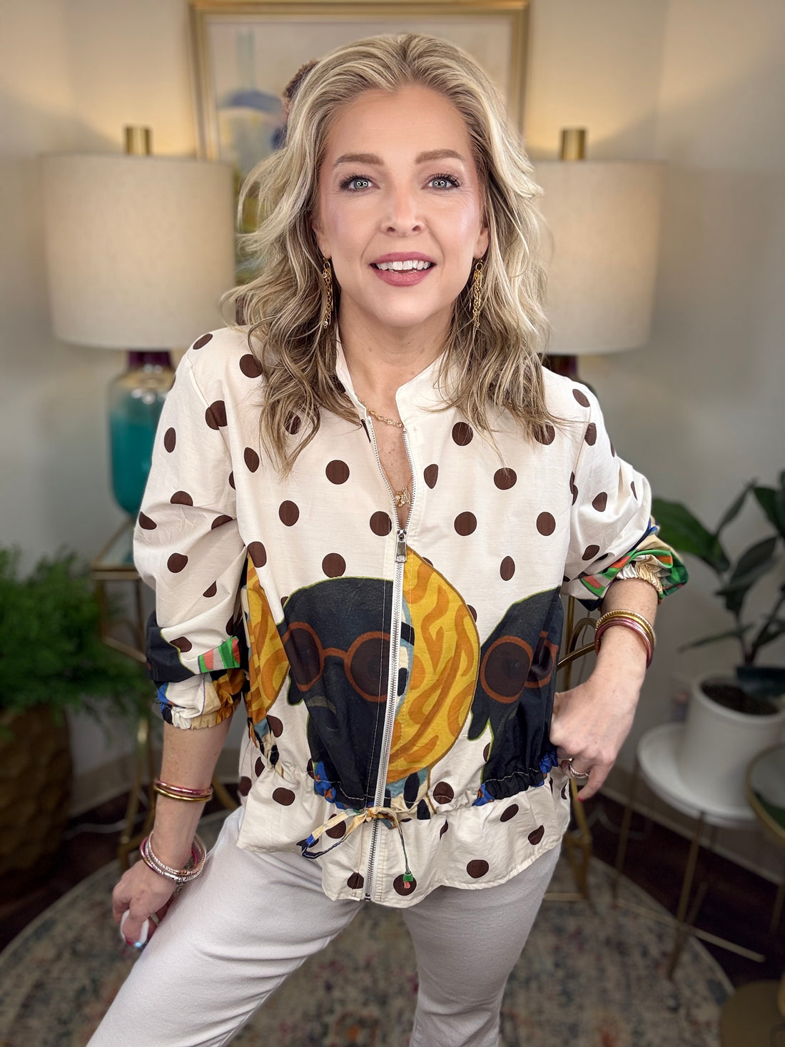 Woman modeling a jacket with puppies and polka dots patterned on it
