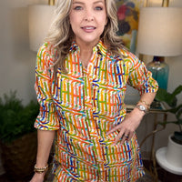 Woman wearing a colorful patterned dress in a home setting