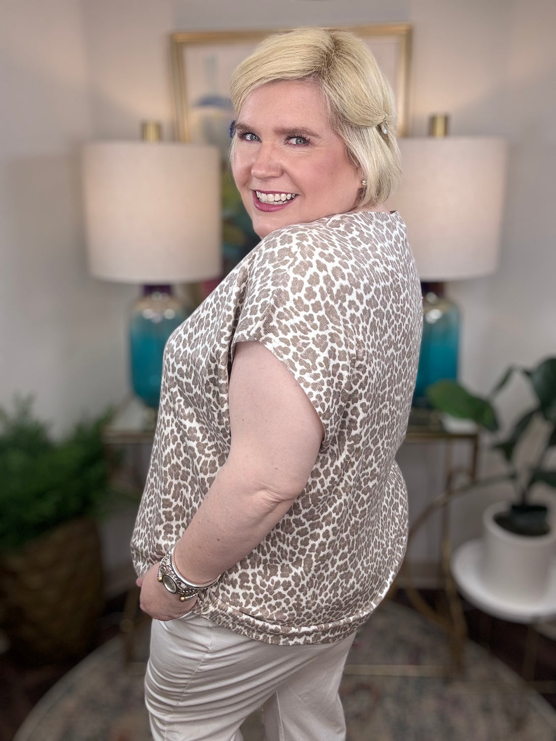 Woman wearing a taupe leopard patterned blouse.