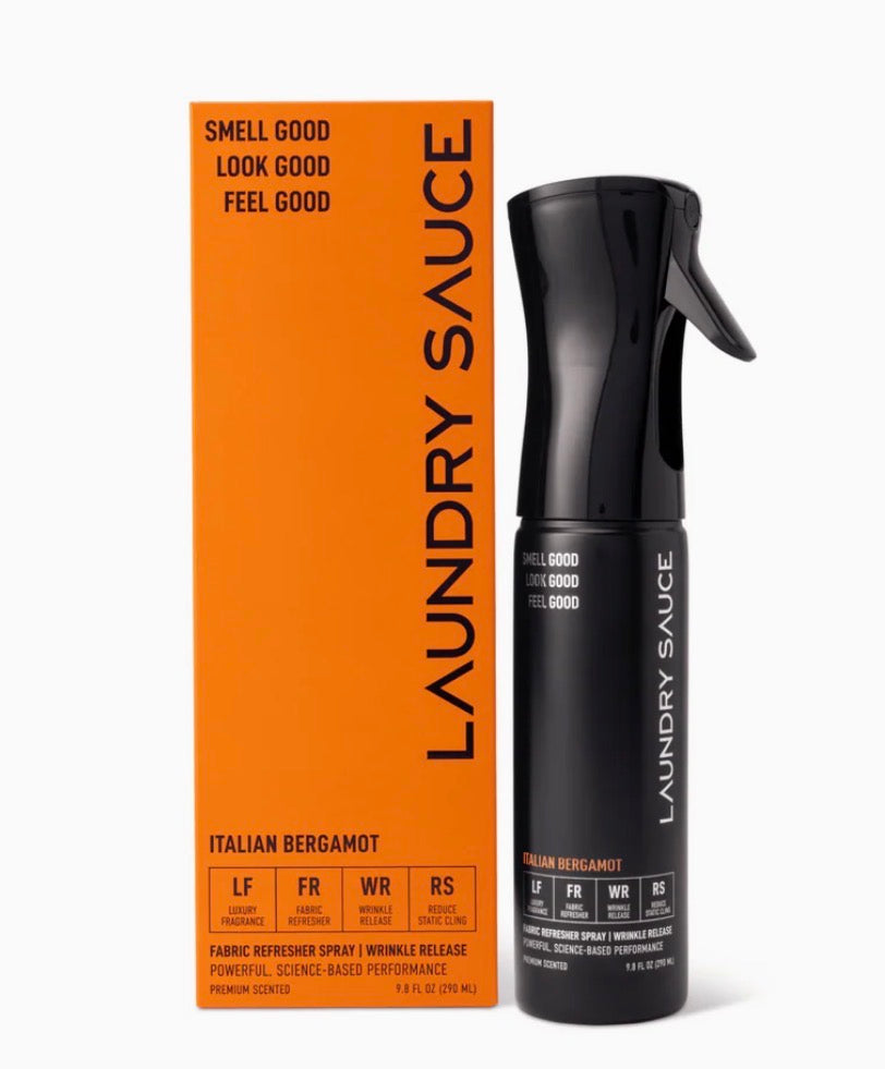 Black spray bottle and orange box of Laundry Sauce on a white background