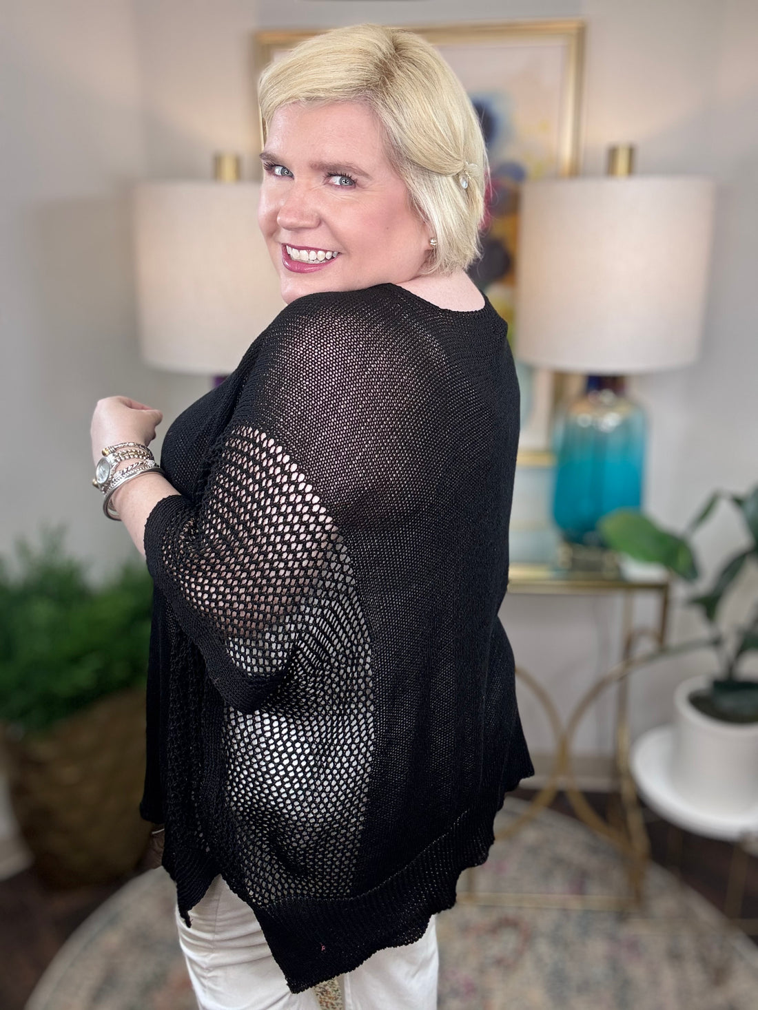 Woman wearing a black short-sleeved tunic sweater.