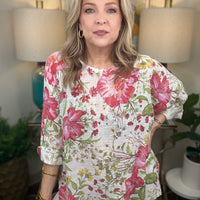 Woman wearing a floral blouse in a room with lamps and plants