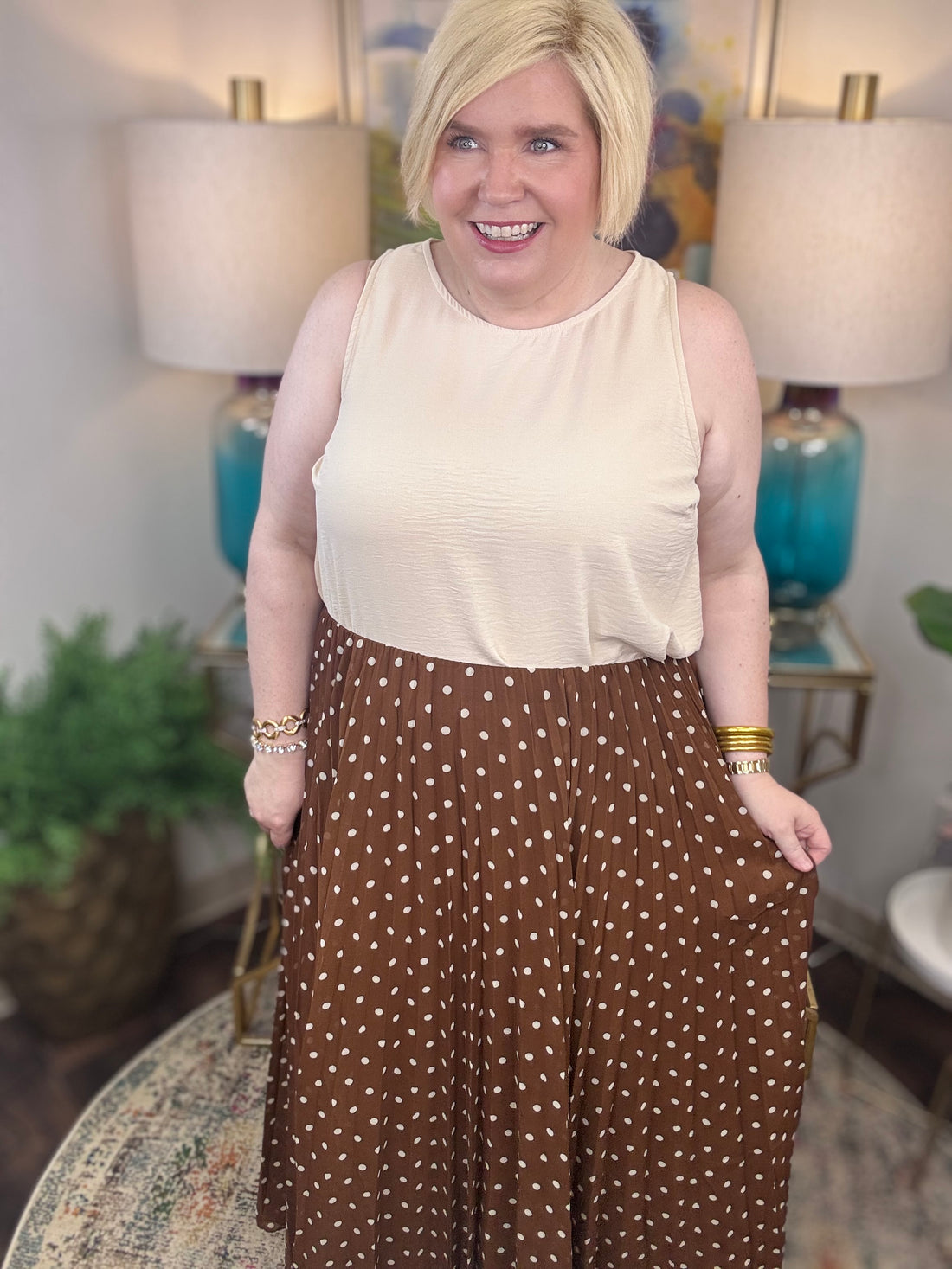 Woman wearing a beige top and brown polka dot skirt