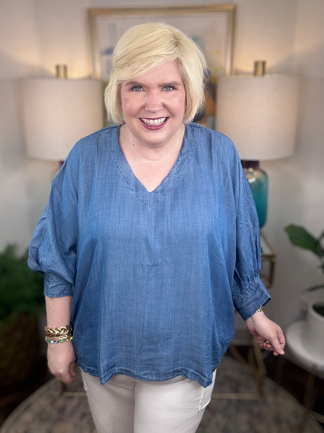 Woman wearing a denim v-neck dolman sleeve blouse