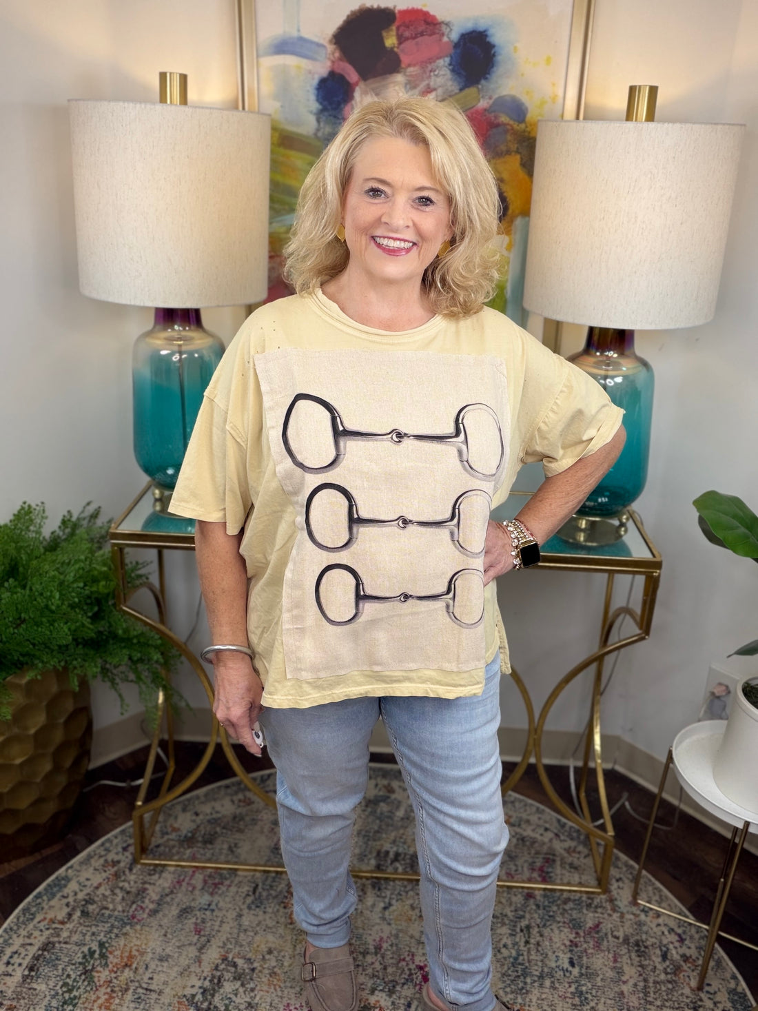 Cream colored oversized t-shirt with lined graphic applique with horsebit pattern