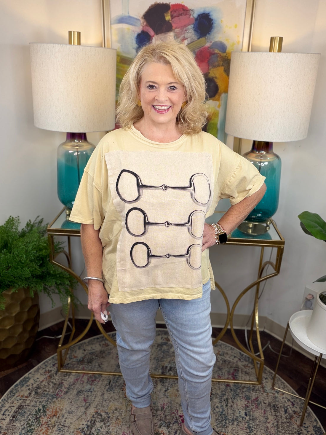 Cream colored oversized t-shirt with lined graphic applique with horsebit pattern