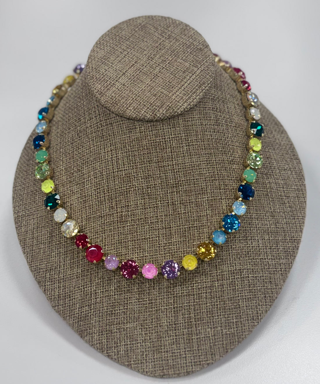 Multicolored beaded necklace on a brown fabric display