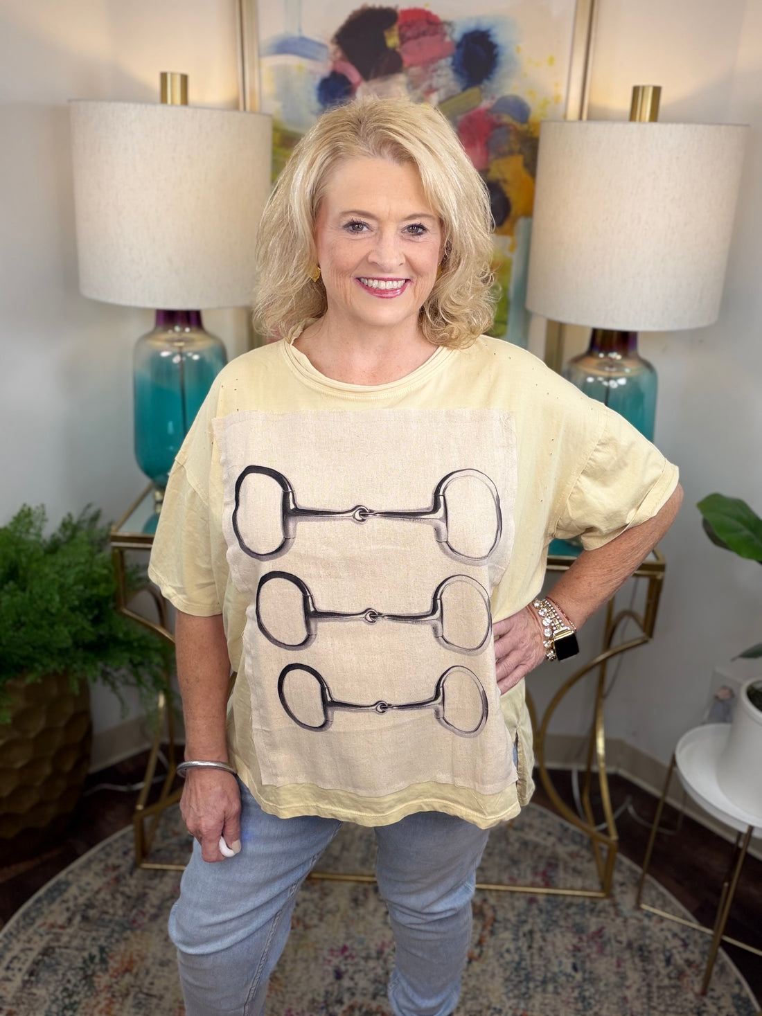 Cream colored oversized t-shirt with lined graphic applique with horsebit pattern