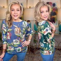 A woman modeling a blue and green tropical-themed knit sweater with a mahjong tile print