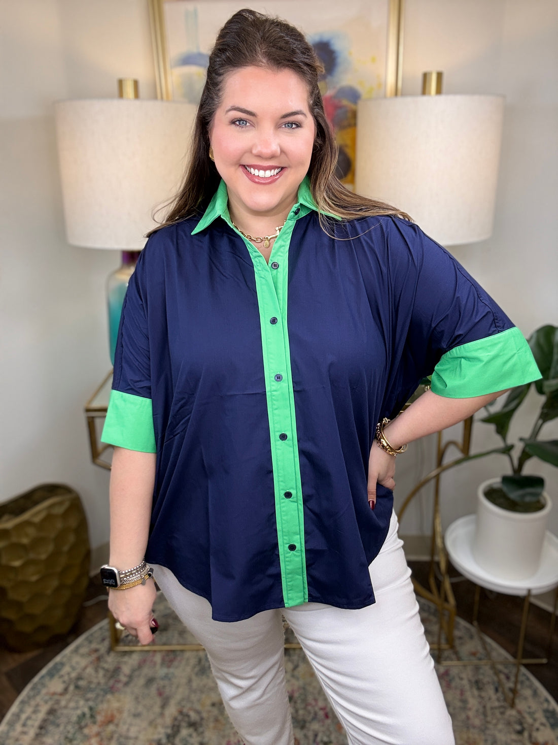 Woman wearing a navy shirt with green color-block accents.