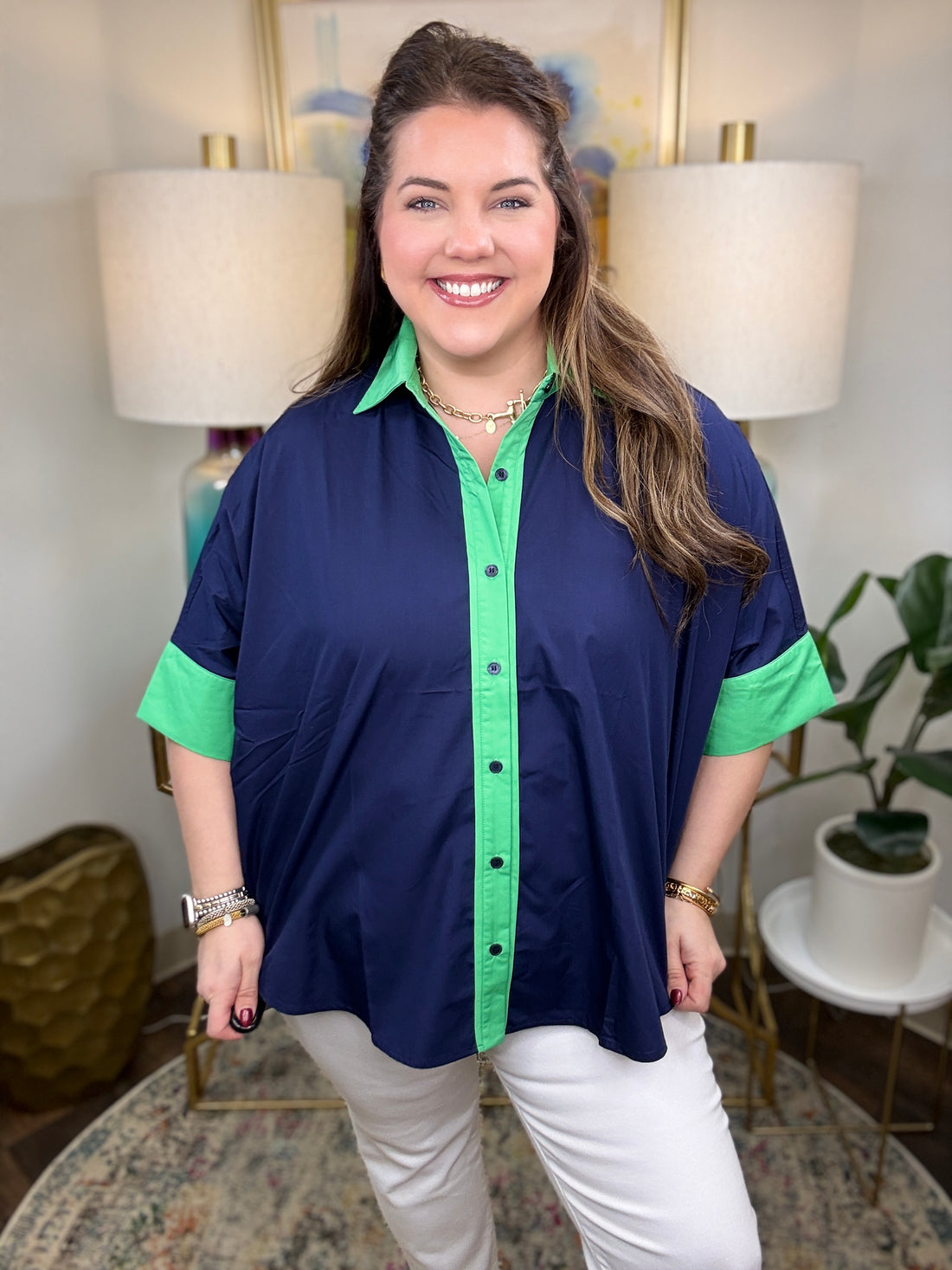Woman wearing a navy shirt with green color-block accents.