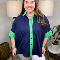 Woman wearing a navy shirt with green color-block accents.