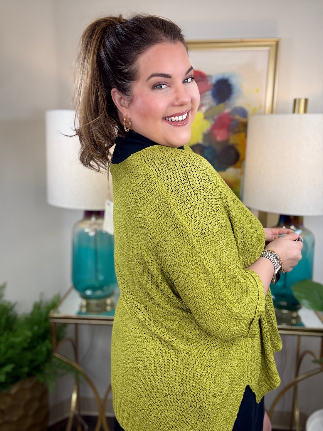Woman wearing a short sleeved chartreuse sweater.