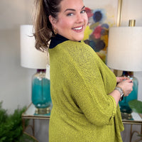 Woman wearing a short sleeved chartreuse sweater.