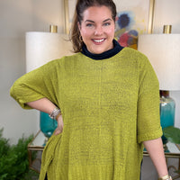 Woman wearing a short sleeved chartreuse sweater.