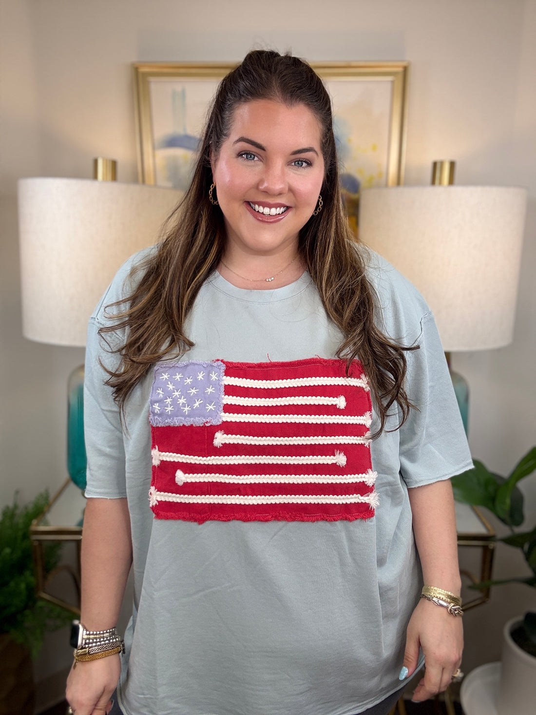 Woman wearing a dusty blue american flag shirt.