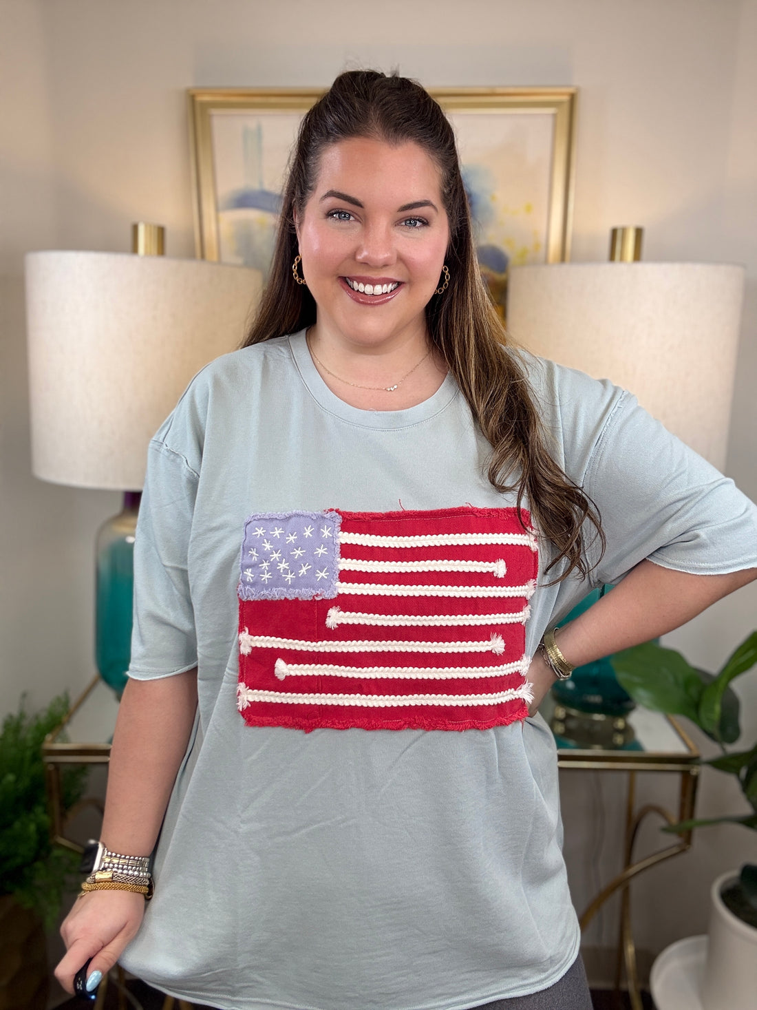Woman wearing a dusty blue American flag shirt.