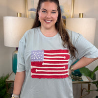 Woman wearing a dusty blue American flag shirt.