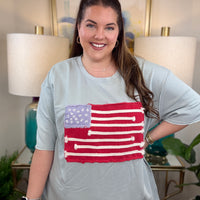 Woman wearing a dusty blue American flag shirt.
