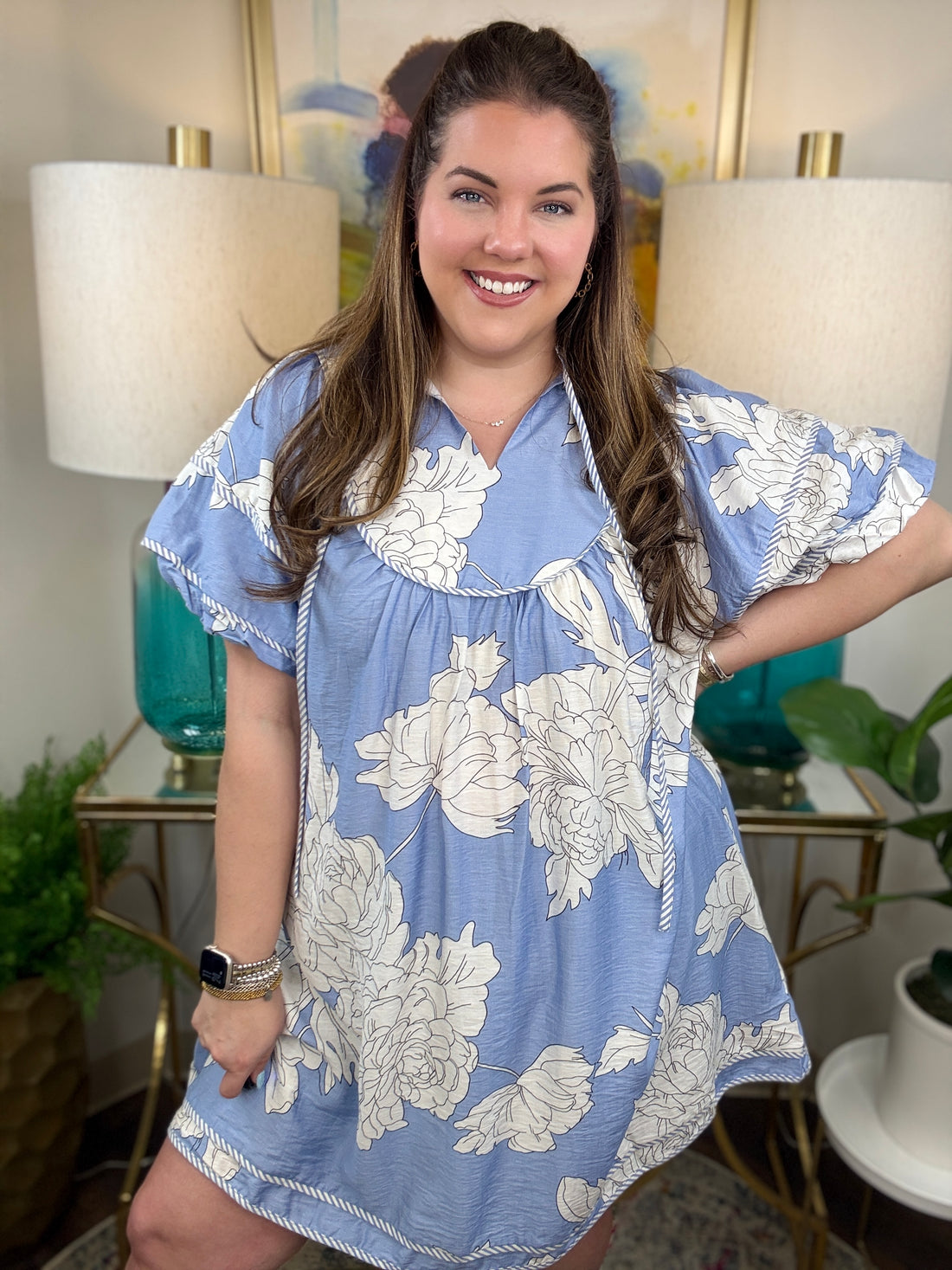 Woman wearing a baby blue floral babydoll dress. 