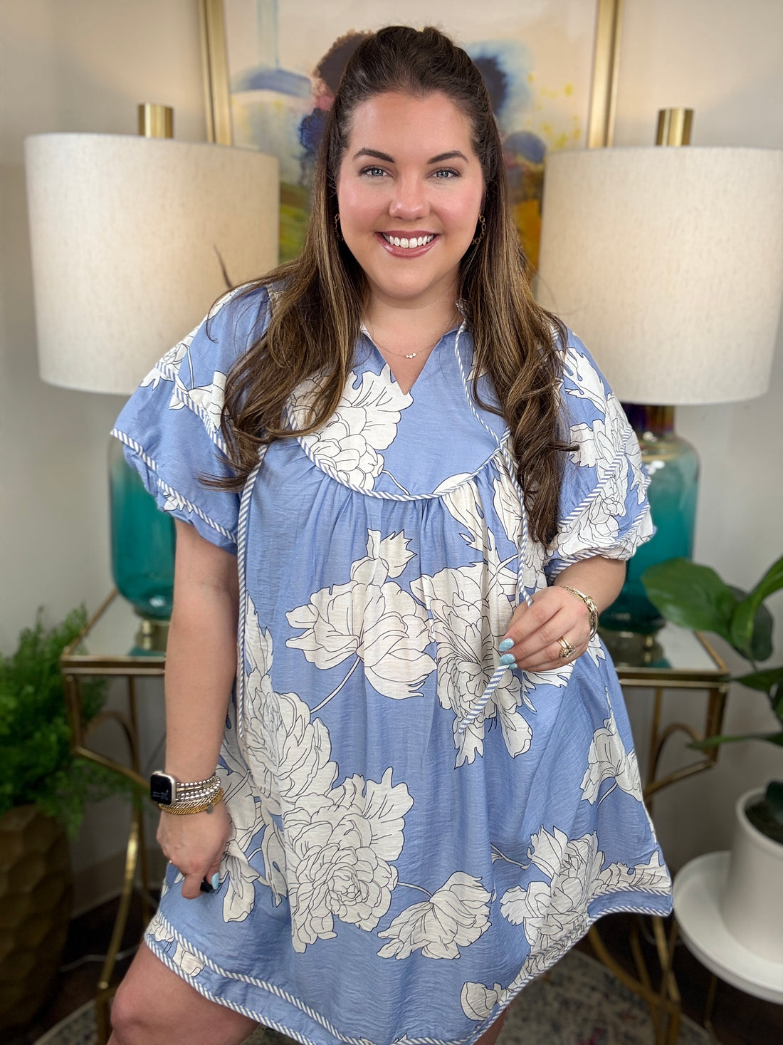 Woman wearing a baby blue floral babydoll dress. 