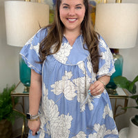 Woman wearing a baby blue floral babydoll dress. 