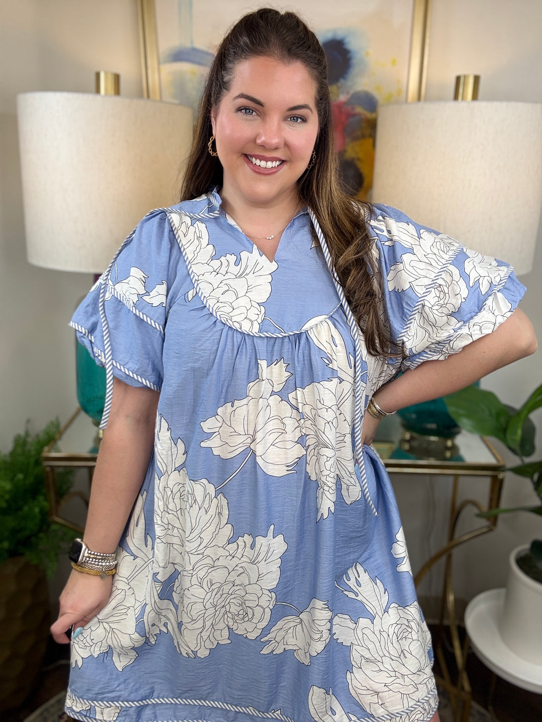 Woman wearing a baby blue floral babydoll dress. 