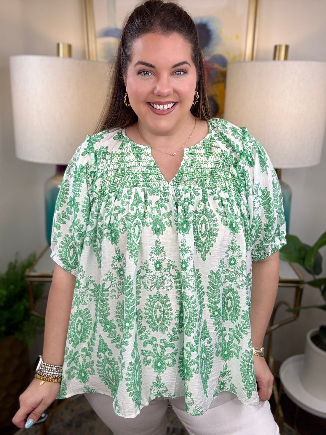 Woman in a green and white print top.