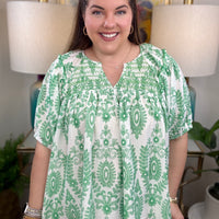 Woman in a green and white print top.
